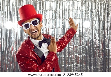 Happy young black man in red disco jacket dance on glitter background. Smiling African American entertainer or showman have fun on party or celebration in nightclub. Entertainment concept. Foto d'archivio © 