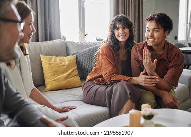 Happy Young Black Woman Boasting With Engagement Ring On Finger To Parents Of Her Girlfriend While Talking About Forthcoming Wedding