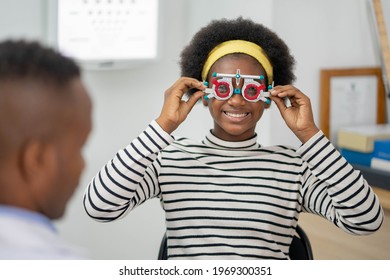Happy Young black woman checking vision with eye test glasses during a medical examination at the ophthalmological office, ophthalmology concept.