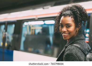 Happy Young Black Woman Inside The Underground Station Waiting For The Train