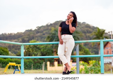 Happy Young Black Woman Talking On Her Smartphone Or Mobile Cell Phone