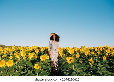 Happy Young Black Woman Walking In A Sunflower Field