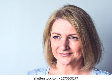 Happy Young Blond Woman With Blue Eyes Smiling And Looking Not At The Camera  Free Background