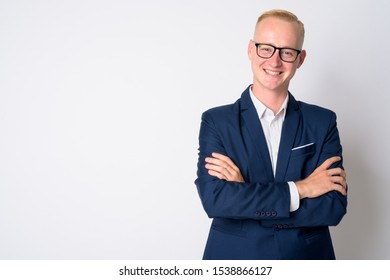 Happy young blonde businessman in suit smiling with arms crossed - Shutterstock ID 1538866127