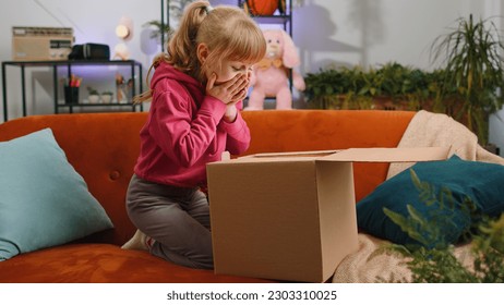 Happy young blonde child kid girl unpacking delivery parcel. Smiling satisfied teen toddler shopper, online shop customer opening cardboard box receiving purchase gift by fast postal shipping at home - Powered by Shutterstock
