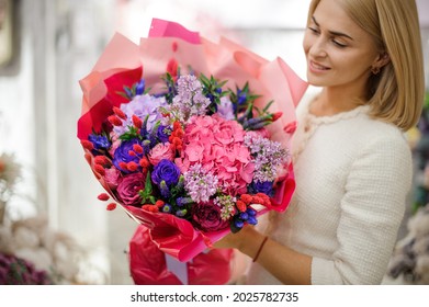 happy young blonde woman holds beautiful bouquet of mixed flowers wrapped in bright pink paper. Floral shop concept. Handsome fresh bouquet. - Powered by Shutterstock