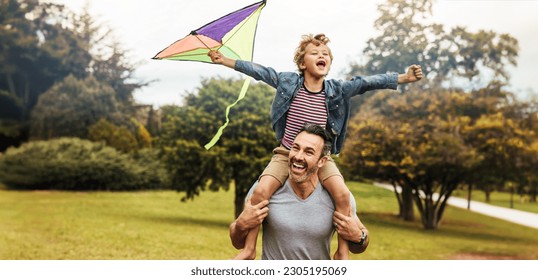 Happy young boy flying a kite while sitting on his father's shoulders, enjoying father's day out in the park. Dad and son bonding and having some outdoor fun during family time. - Powered by Shutterstock