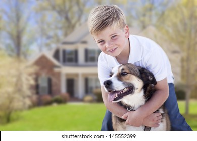 Happy Young Boy And His Dog In Front Yard Of Their House.