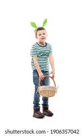 Happy young boy holding and carrying heavy Easter basket full of painted Easter eggs. Full length isolated on white background.