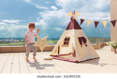 Happy Young Boy, Kid Playing Near The Textile Wigwam Tent On The Summer Patio