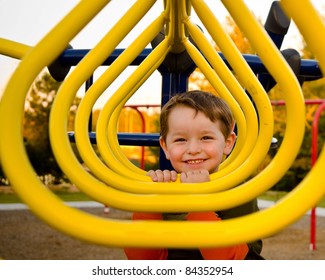 Happy Young Boy Or Kid Playing On Monkey Bars At Playground.