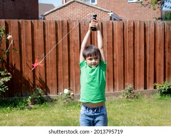 Happy young boy playing plastic airplane in the garden, Kid having fun flying plane toy outside in sunnyday summer, Active child playing outdoor in weekend.