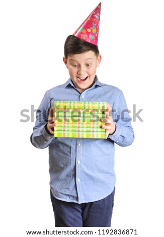 Happy young boy with a red party hat holding a green present box isolated on white background