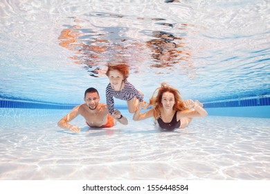 Happy Young Boy Swim And Dive Underwater With Parents, Kid Breaststroke With Fun In Pool. Active Healthy Lifestyle, Water Sport Activity And Lessons Summer Family Vacation With Child.