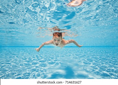 Happy young boy swim and dive underwater, kid breast stroke with fun in pool. Active healthy lifestyle, water sport activity and lessons with parents on summer family vacation with child.