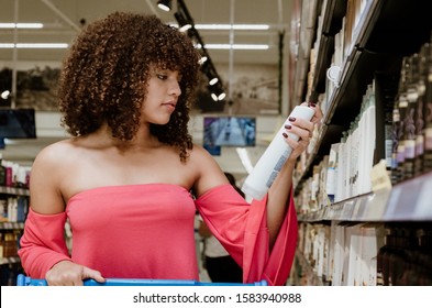 Happy Young Brunette With Curly Hair Buying Shampoo In Supermarket