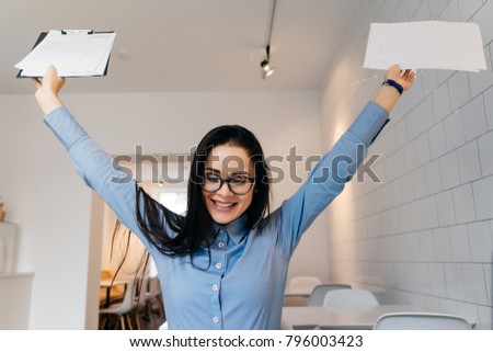 happy young brunette girl in blue shirt and glasses performed all the work during
