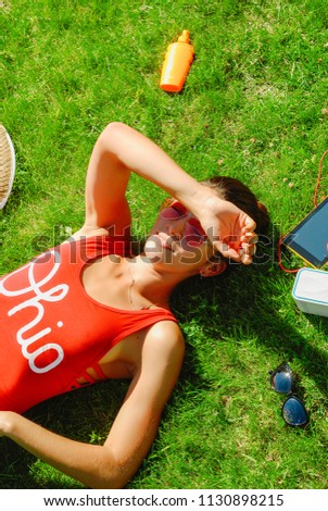 happy young brunette woman listening to the music outdoor on a summer day