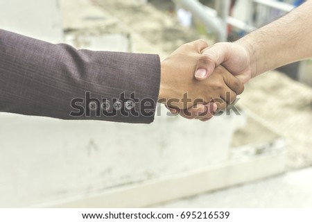 Happy young businesman giving handshaking in congratulation during meeting in town. celebrating success of startup project.Tag team concept.Split tone pinterest and instragram like process.
