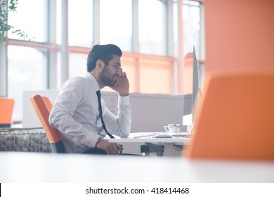 happy young business man  working on desktop computer at his desk in modern bright startup office interior - Shutterstock ID 418414468