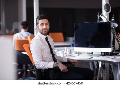 Happy Young Business Man  Working On Desktop Computer At His Desk In Modern Bright Startup Office Interior