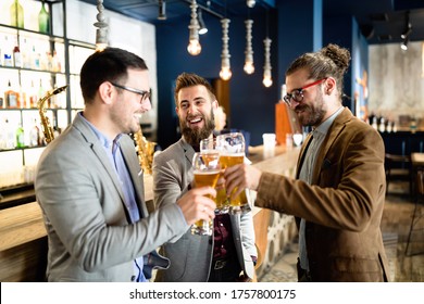 Happy young business men talking and drinking beer in a pub - Powered by Shutterstock