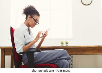 Happy Young Business Woman In Formalwear Texting On Smartphone, While Sitting At Office, Copy Space, Side View