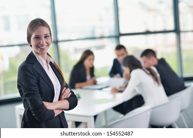 Happy Young Business Woman  With Her Staff,  People Group In Background At Modern Bright Office Indoors