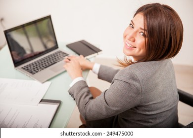 Happy Young Business Woman Working On Some Documents On Her Laptop Computer