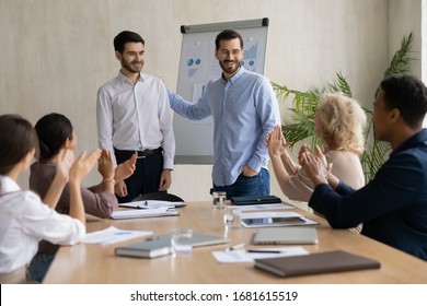 Happy Young Businessman Introduce New Male Employee Newcomer At Office Meeting, Man Boss Congratulate Worker With Promotion Or Achievement, Colleagues Applaud, Acknowledgment Concept