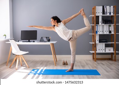 Happy Young Businesswoman Doing Stretching Exercise At Workplace - Powered by Shutterstock