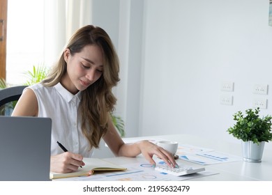 Happy Young Businesswoman Using Calculator At Workplace