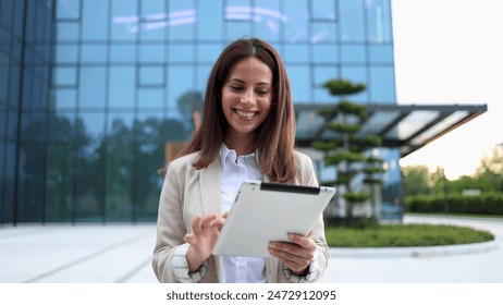 Happy, young businesswoman using tablet and enjoying outdoors - Powered by Shutterstock