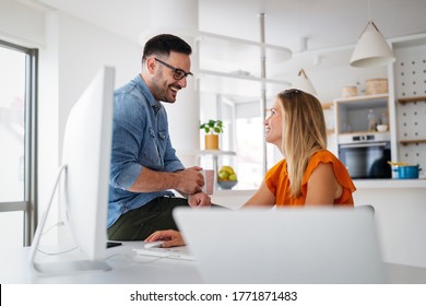 Happy young casual couple sitting at desk working together at home office - Shutterstock ID 1771871483