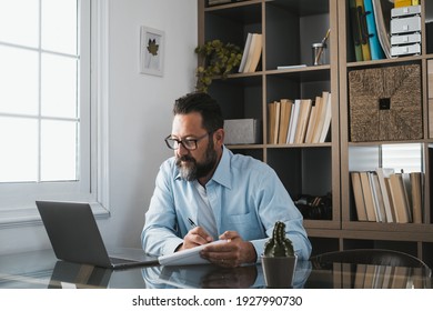 Happy Young Caucasian Businessman Smiling Working Online Watching Webinar Podcast On Laptop And Learning Education Course Conference Calling Make Notes Sit At Work Desk, Elearning Concept