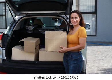 Happy Young Caucasian Family Carry Boxes From Car And Entering New House Together