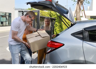 Happy young caucasian family carry boxes from car and entering new house together - Powered by Shutterstock