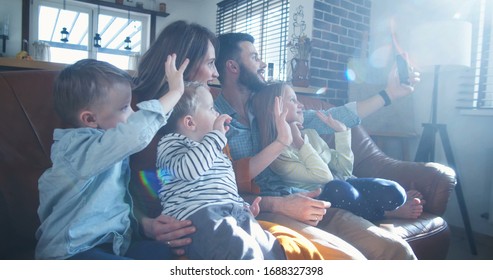 Happy Young Caucasian Family With Three Kids Wave To Friends Talking During Smartphone Video Call At Home Slow Motion.