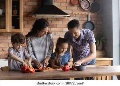 Happy Young Caucasian Family With Two Little Kids Have Fun Cooking Healthy Breakfast In Kitchen Together. Smiling Parents With Small Children Prepare Diet Vegetarian Salad In Own Home In The Morning.