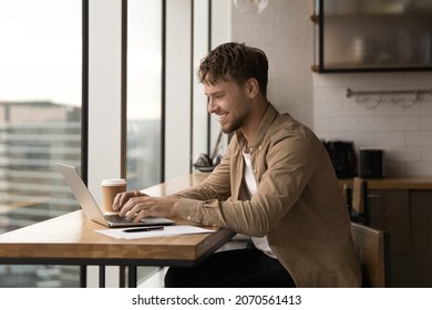 Happy young caucasian male manager working on computer in modern office, solving online project problems distantly, using software applications, typing message communicating with clients or colleagues - Shutterstock ID 2070561413