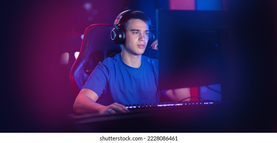 Happy Young caucasian man pro gamer streamer play in online video game, neon color soft focus. Concept banner esport tournament. - Powered by Shutterstock