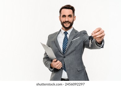 Happy young Caucasian realtor giving keys from new apartment isolated over white background. Banker real estate agent seller owner tenant with keys and clipboard, ready to move in - Powered by Shutterstock