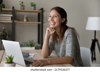 Happy Young Caucasian Red-haired Woman Sit At Desk Distracted Form Computer Work Look In Distance Laughing Dreaming, Overjoyed Millennial Female Work On Laptop Talk With Someone, Happiness Concept