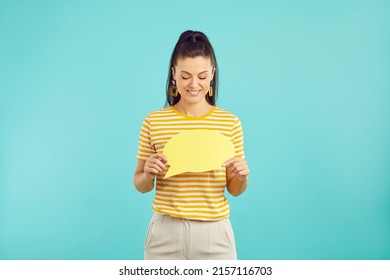 Happy Young Caucasian Woman Hold Speech Bubble With Empty Space For Advertising Placement. Smiling Girl With Talk Balloon Show Good Sale Or Offer. Copy Space. Blue Green Studio Background.