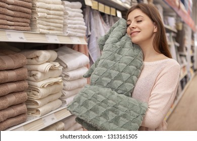 Happy Young Charming Woman Smiling With Her Eyes Closed, Holding Soft Faux Fur Blanket To Her Face. Lovely Female Customer Buying New Blanket At Home Goods Department. Woman Shopping For Linens