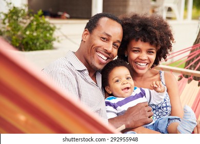 Happy coupleÃ?Â¿with young child sitting in a hammock