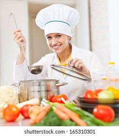 Happy Young Cook Tests Vegetarian Food With Ladle At Commercial Kitchen  