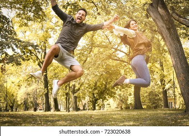 Happy young couple activity in park. Couple jumping in height.