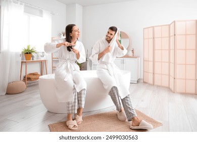 Happy young couple after shower in bathroom - Powered by Shutterstock