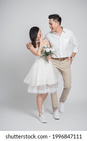 Happy Young Couple Asian Groom And Bride In Casual Wedding Dress Walking And Having Fun Together On White Background 